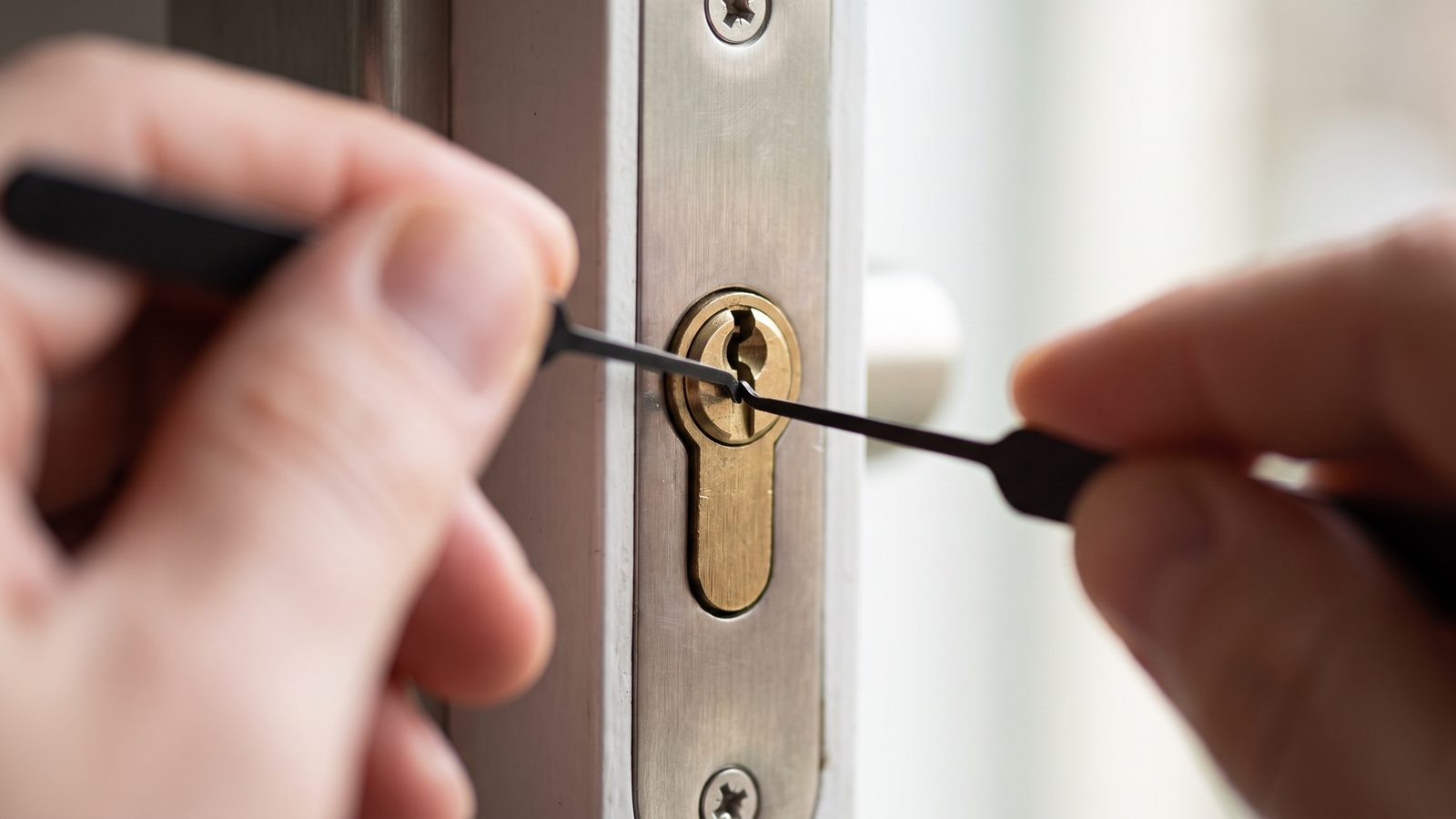 Locksmith picking a door lock cylinder during an emergency lockout