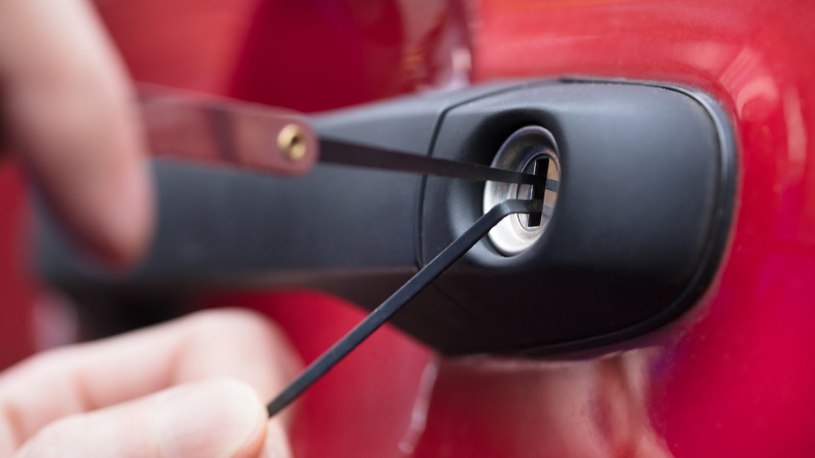 Locksmith opening a car door lock with pick tools after keys were locked in a car in Miami