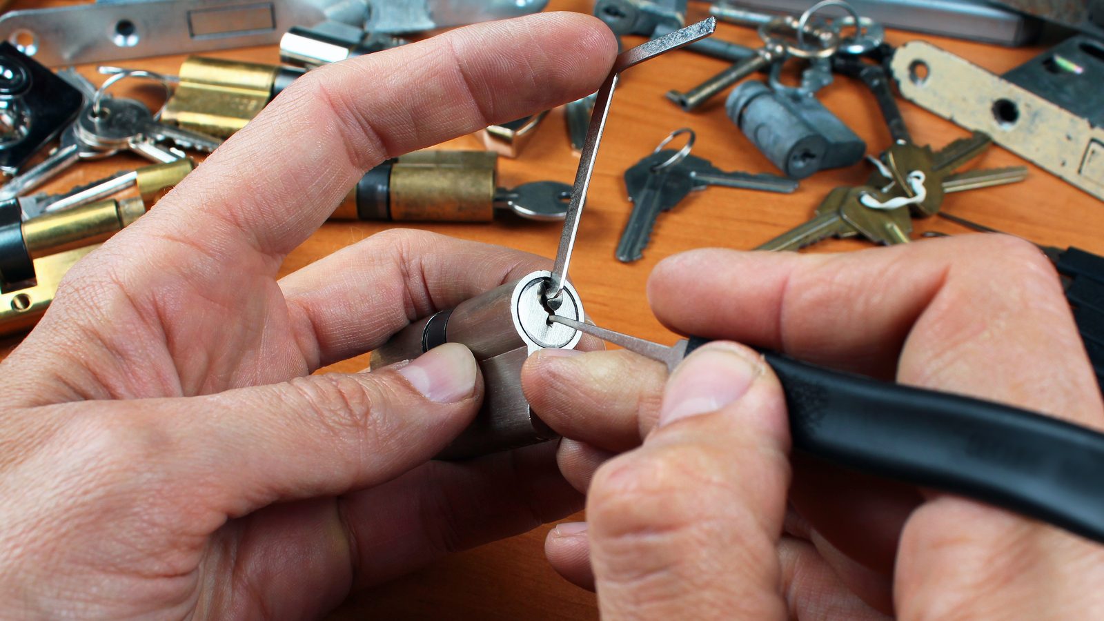Locksmith working on a lock cylinder at a bench with keys and lock parts, rekeying locks in Miami